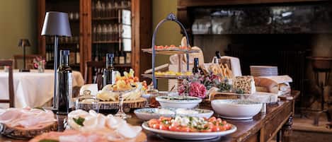 A buffet table with various food items and a wine selection.