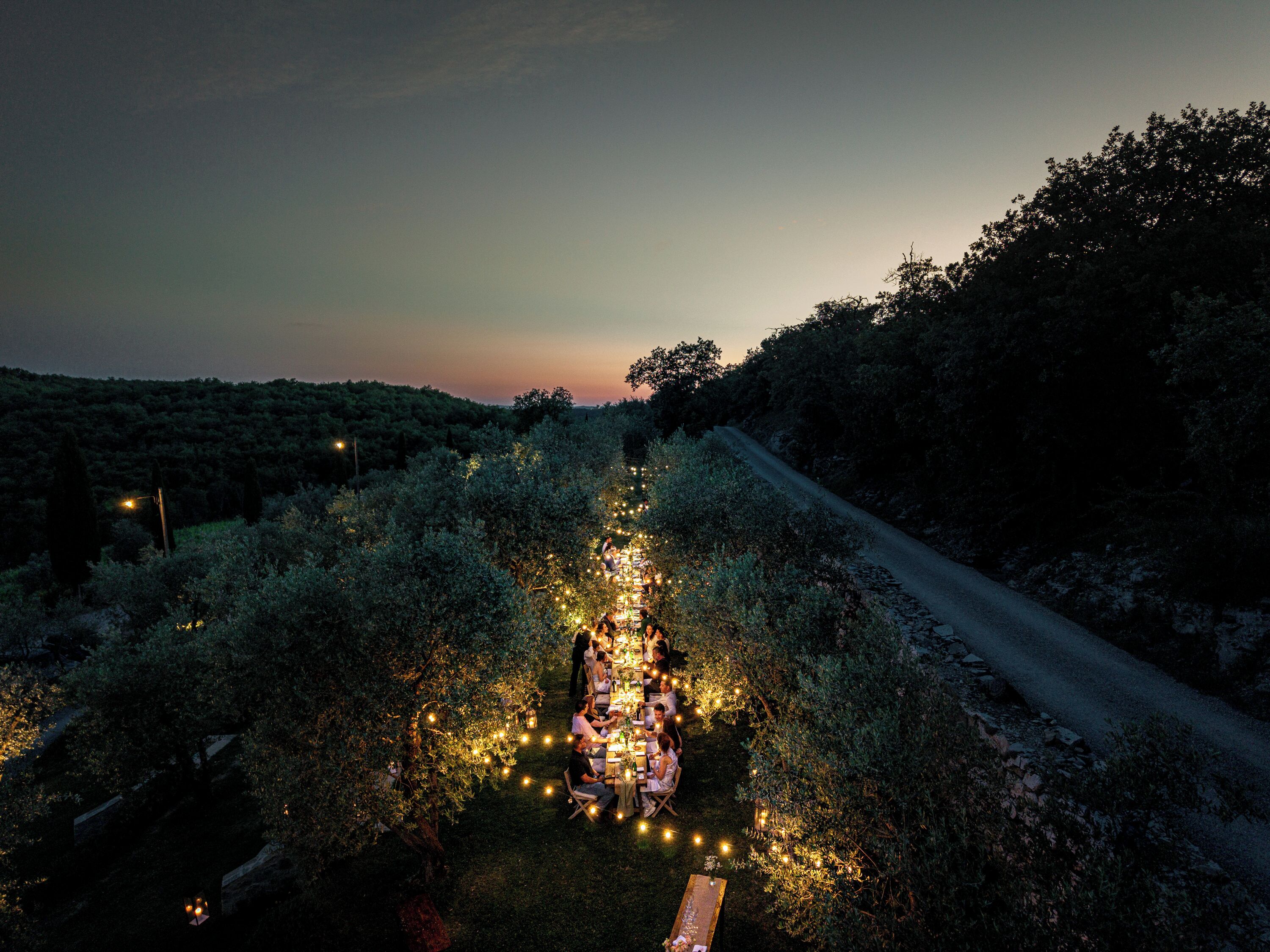 An outdoor dining area with string lights and tables set up in a garden.