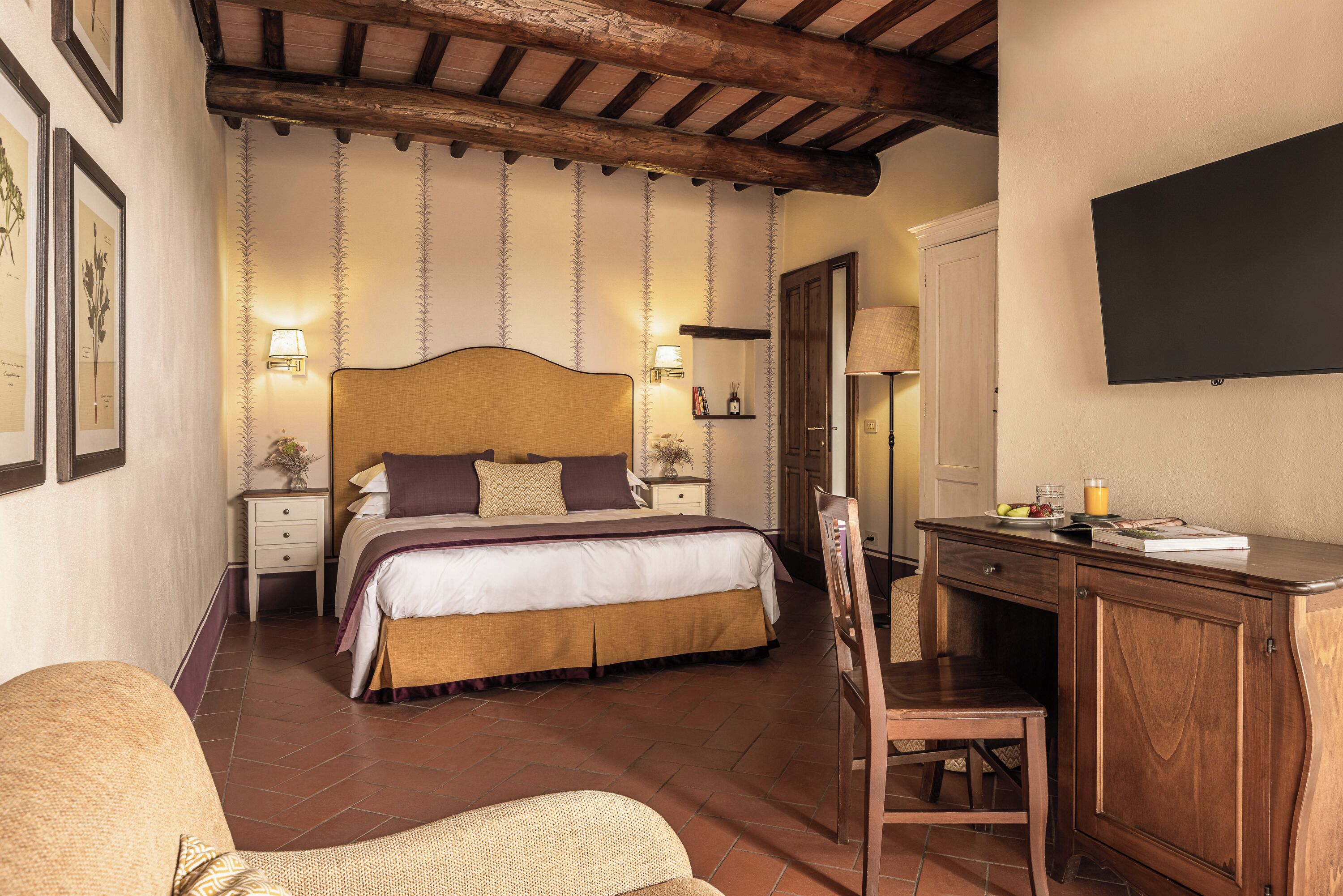 A bedroom with a bed, bedside tables, a desk, and a chair.