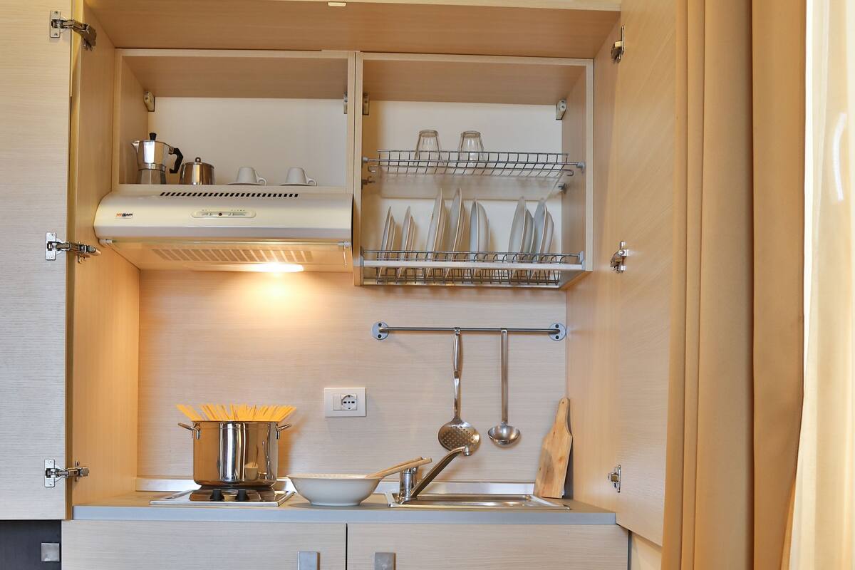 A compact kitchen with a sink, stove, and utensil storage.