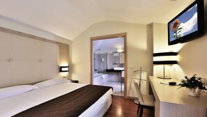 A hotel room with a bed, a desk, a chair, a mirror, and a TV. - Regal Hotel (Brescia)
