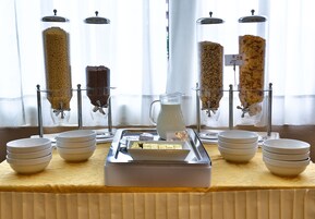 Un buffet de petit-déjeuner proposant divers aliments et une carafe de lait.