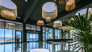 A spacious lobby with large windows, a polished marble floor, and modern circular light fixtures. - Grand Hotel Adriatic I (Opatija)