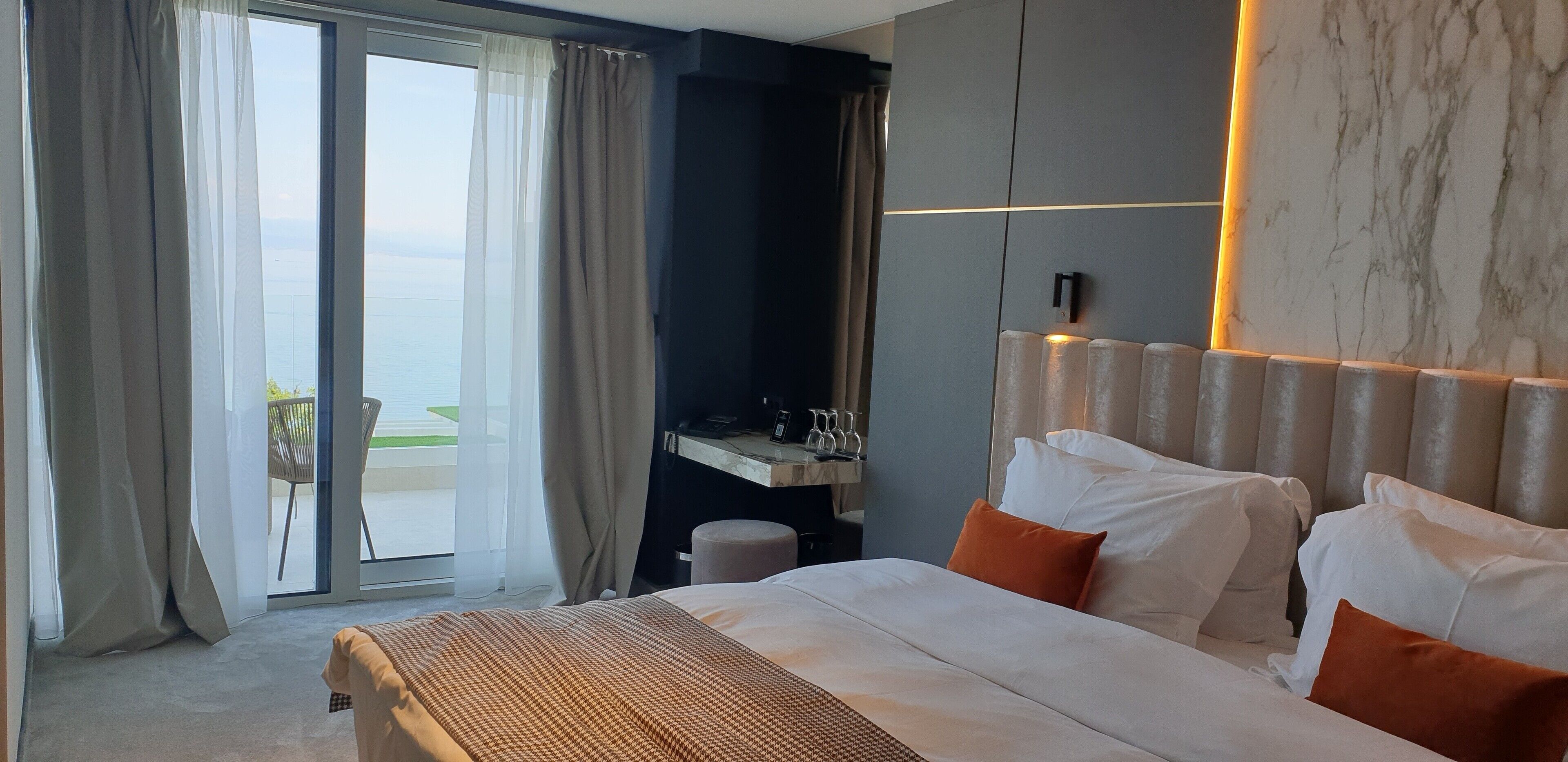 Ein Hotelzimmer mit Bett, Schreibtisch und Blick ins Freie.