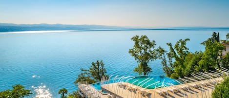 Una piscina cubierta, una piscina al aire libre de temporada, sombrillas