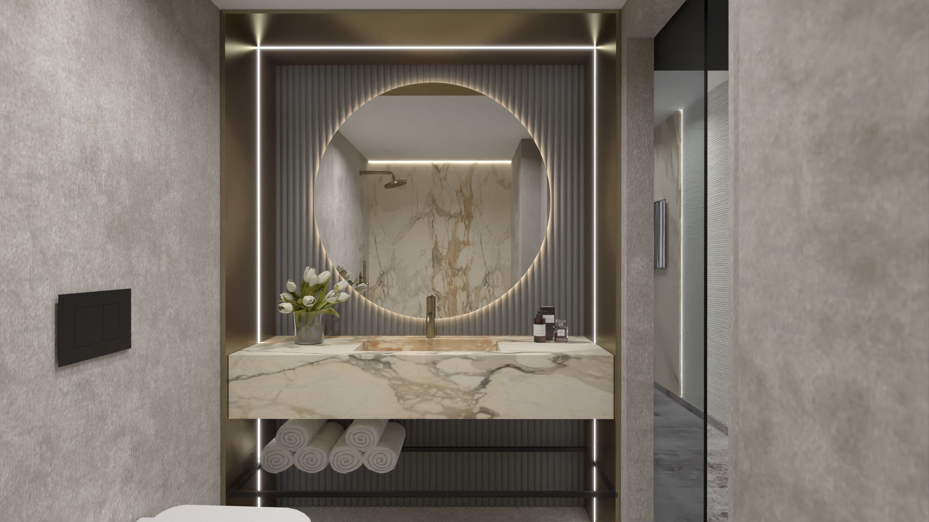 Un baño moderno con un tocador de mármol, un espejo grande con marco circular y un florero con flores blancas.