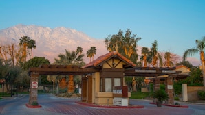 Entrada a un resort con un cartel que indica '8' de altura y 'Palm Canyon 2345 Cherokee'.