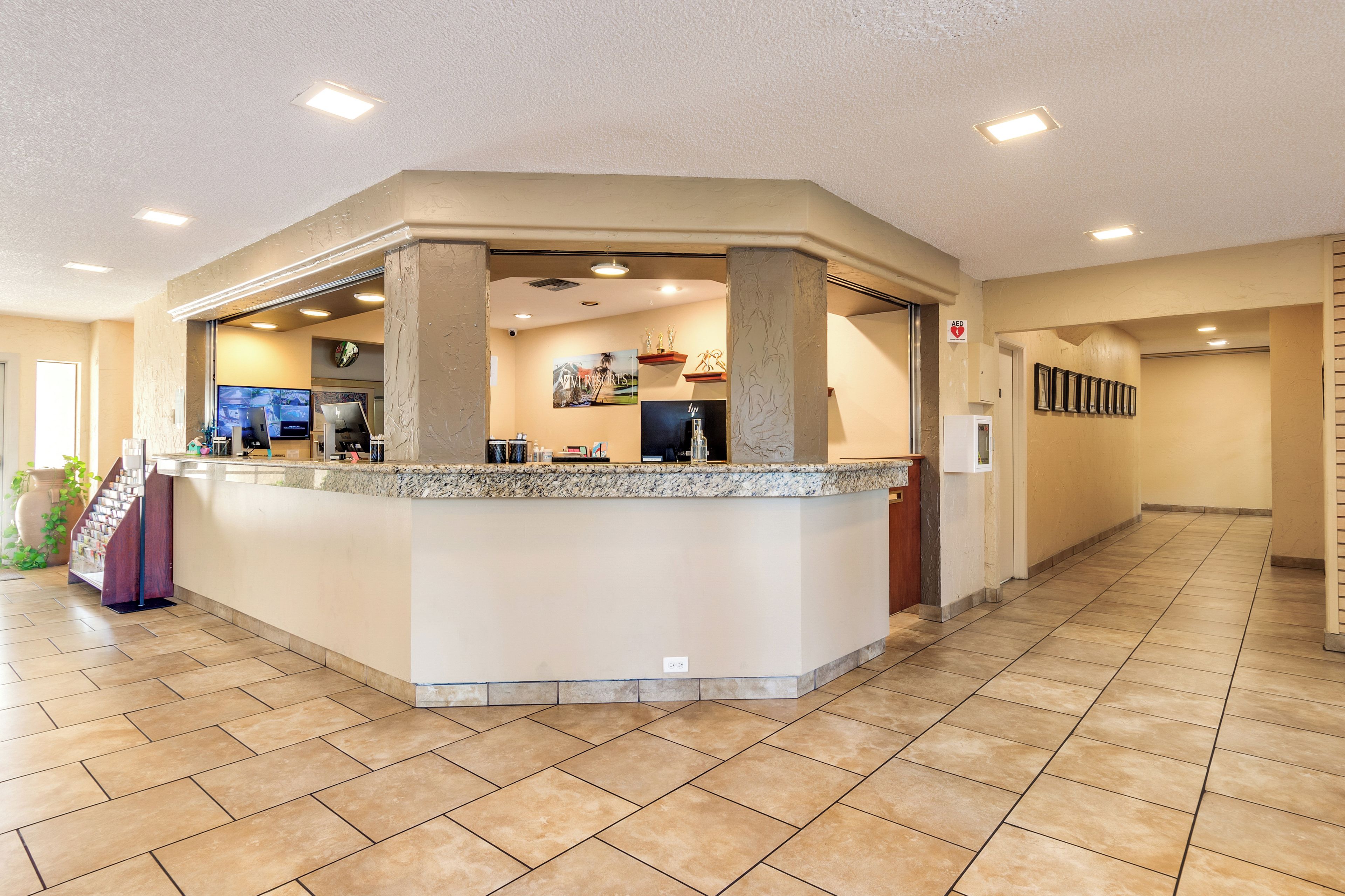 A reception area with a counter, a clock, and a sign indicating an emergency exit.