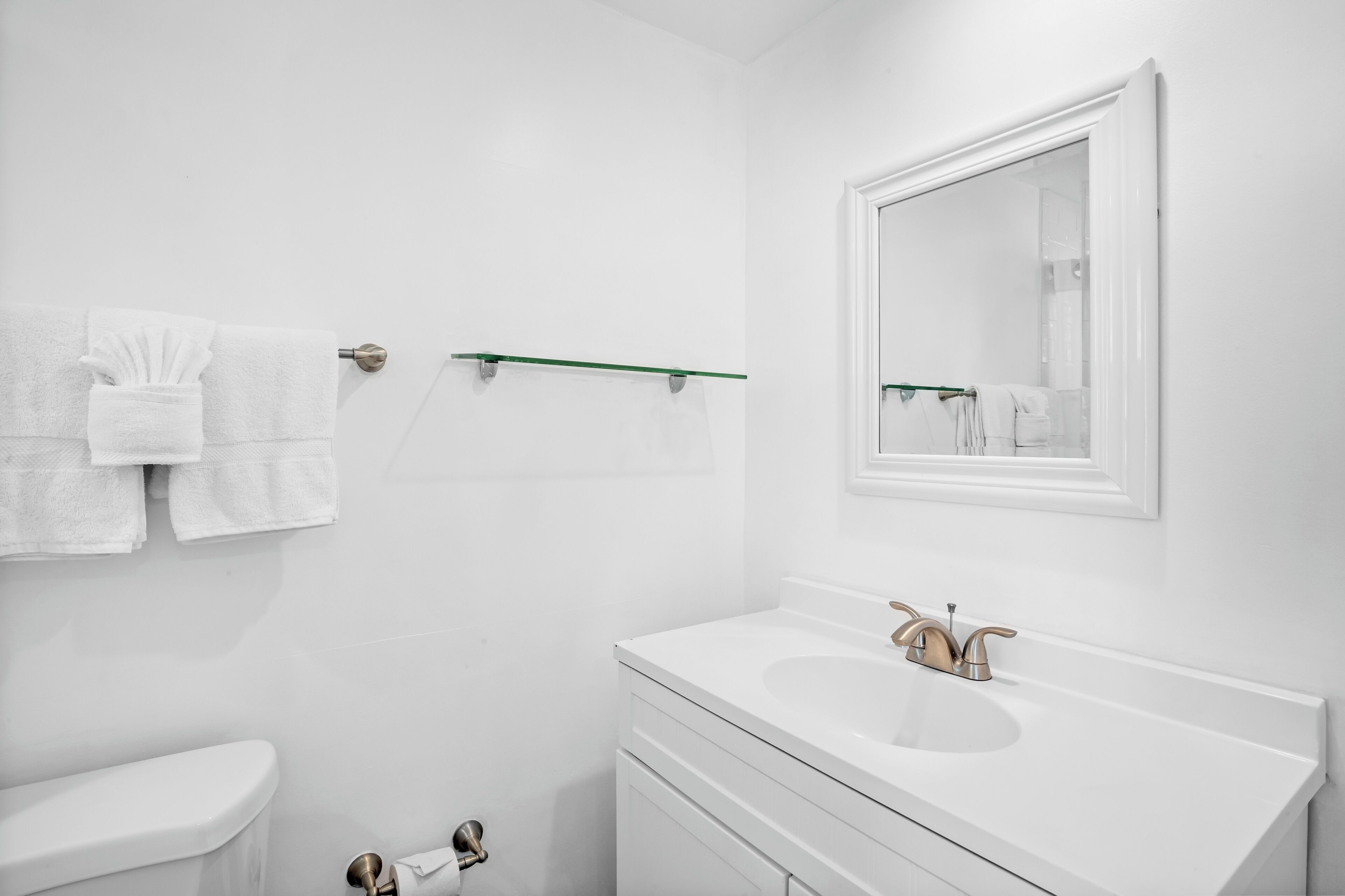 Ein modernes Badezimmer mit Waschbecken, Spiegel und Handtuchhalter.