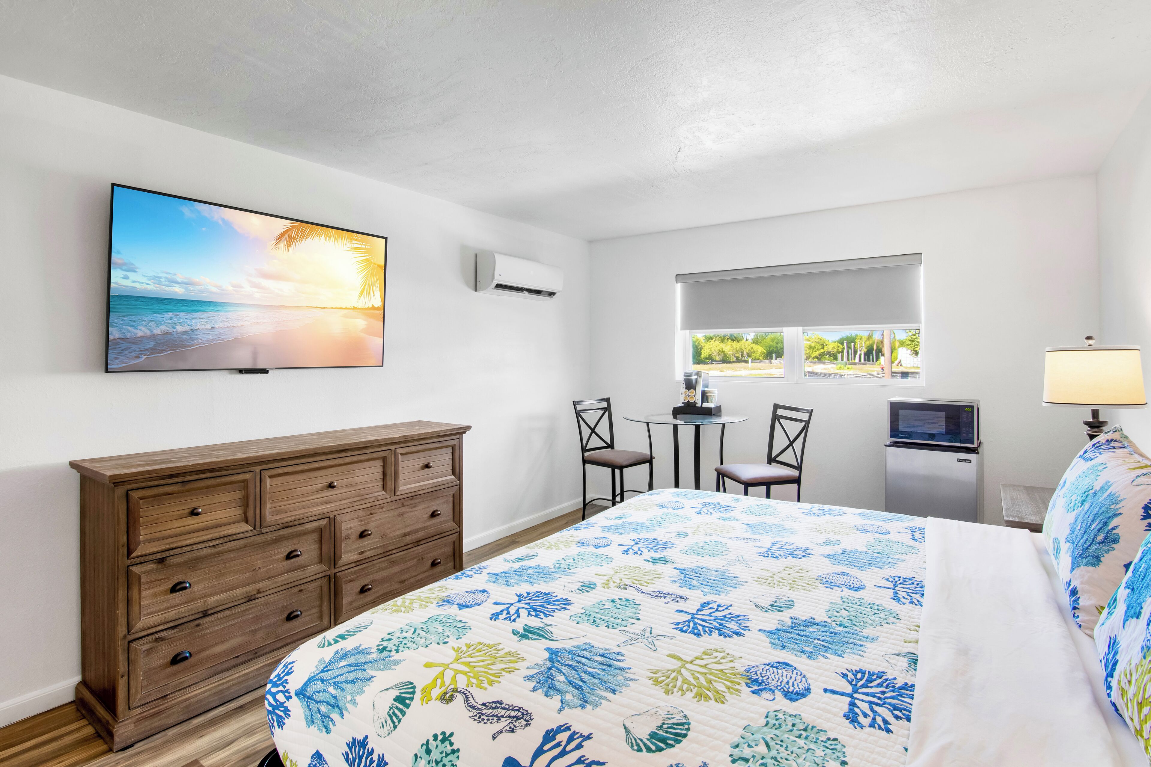 Ein Schlafzimmer mit Bett, Fernseher, Schreibtisch und Stuhl.