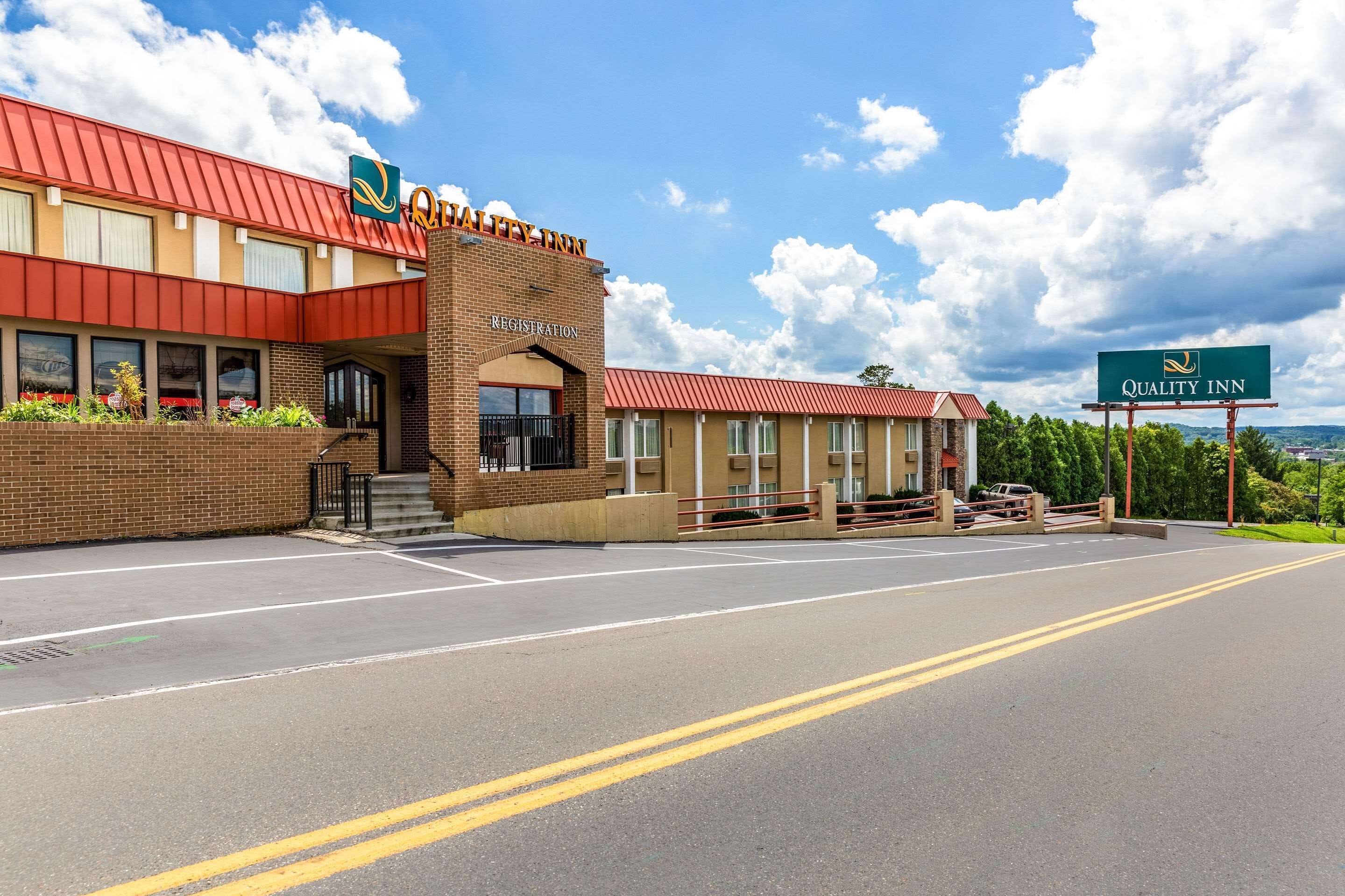 A Quality Inn with a red roof, brick exterior, and a registration area.