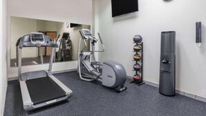 A fitness room with a treadmill, elliptical, and a set of weights. - Days Inn by Wyndham Sherman (Sherman)