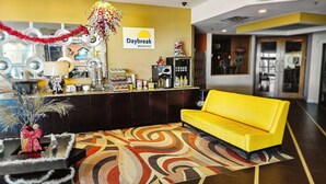 A hotel lobby with a reception desk, a yellow sofa, and a patterned carpet. - Days Inn by Wyndham Sherman (Sherman)