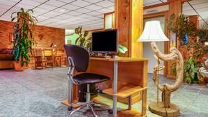 A reception desk with a computer, a chair, and a lamp. - Howard Johnson Helena (Helena)