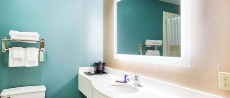 A bathroom with a white sink, a mirror, and a toilet.