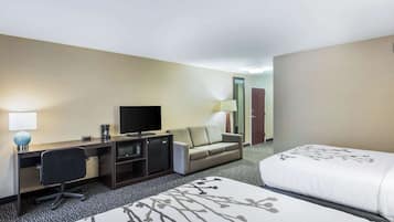 Een hotelkamer met een bed, een bureau, een stoel, een televisie, een bank en een lamp.