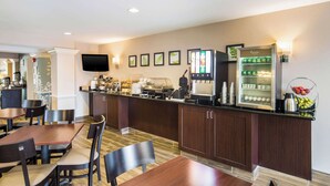 A hotel lobby with a reception desk, seating area, and a coffee machine. - Sleep Inn & Suites Dunmore (Scranton)