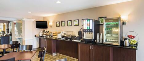 A hotel lobby with a reception desk, seating area, and a coffee machine.