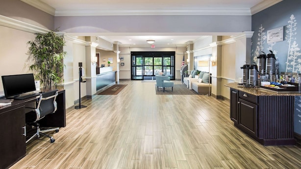 A spacious lobby with a reception desk, a seating area, and a coffee station. - Sleep Inn & Suites Dunmore (Scranton)