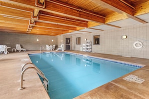 Una piscina techada, sillones reclinables de piscina