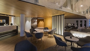 Un interno moderno con una reception, un'area salotto e una scala.