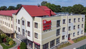A multi-story hotel with a red roof and a sign reading "Best Viesnica Hotel". - Best Hotel (Riga)