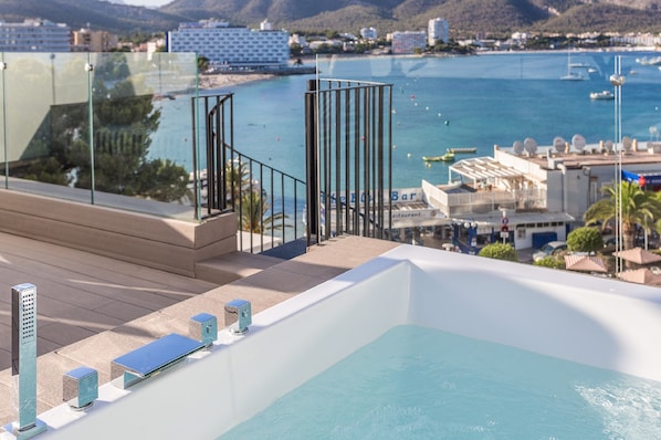 A rooftop pool with a glass balustrade, a bar area, and a view of the sea and buildings. - FERGUS Style Tobago - Adults Only (Calvia)
