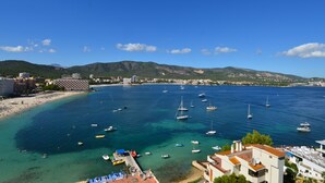 Un pueblo costero con playa, barcos y edificios.