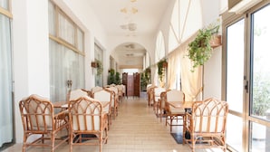 A long corridor with wicker furniture and large windows. - Hotel Marina (Jesolo)