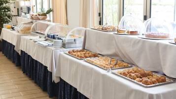 A buffet setup with various food items and a coffee station.