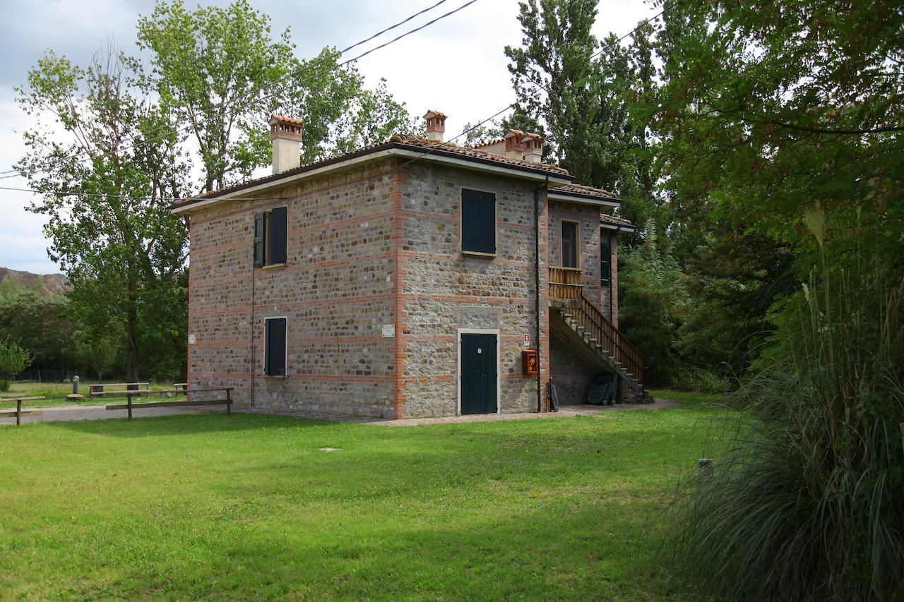 Un bâtiment en pierre de deux étages, avec un escalier en bois menant à l’étage supérieur.
