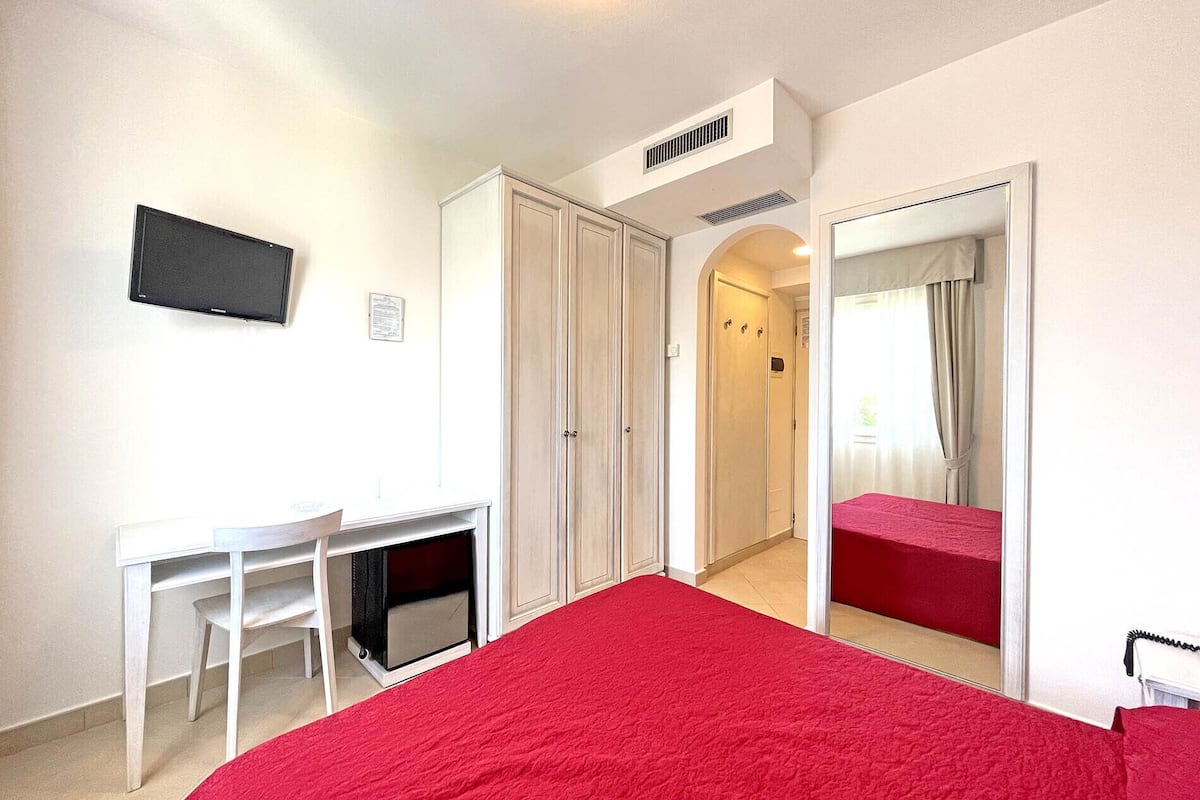 Une chambre à coucher avec un lit, un bureau et une armoire.