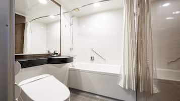 A modern bathroom with a white toilet, a bathtub, and a shower.