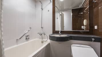 Een moderne badkamer met een bad, een wastafel en een toilet.
