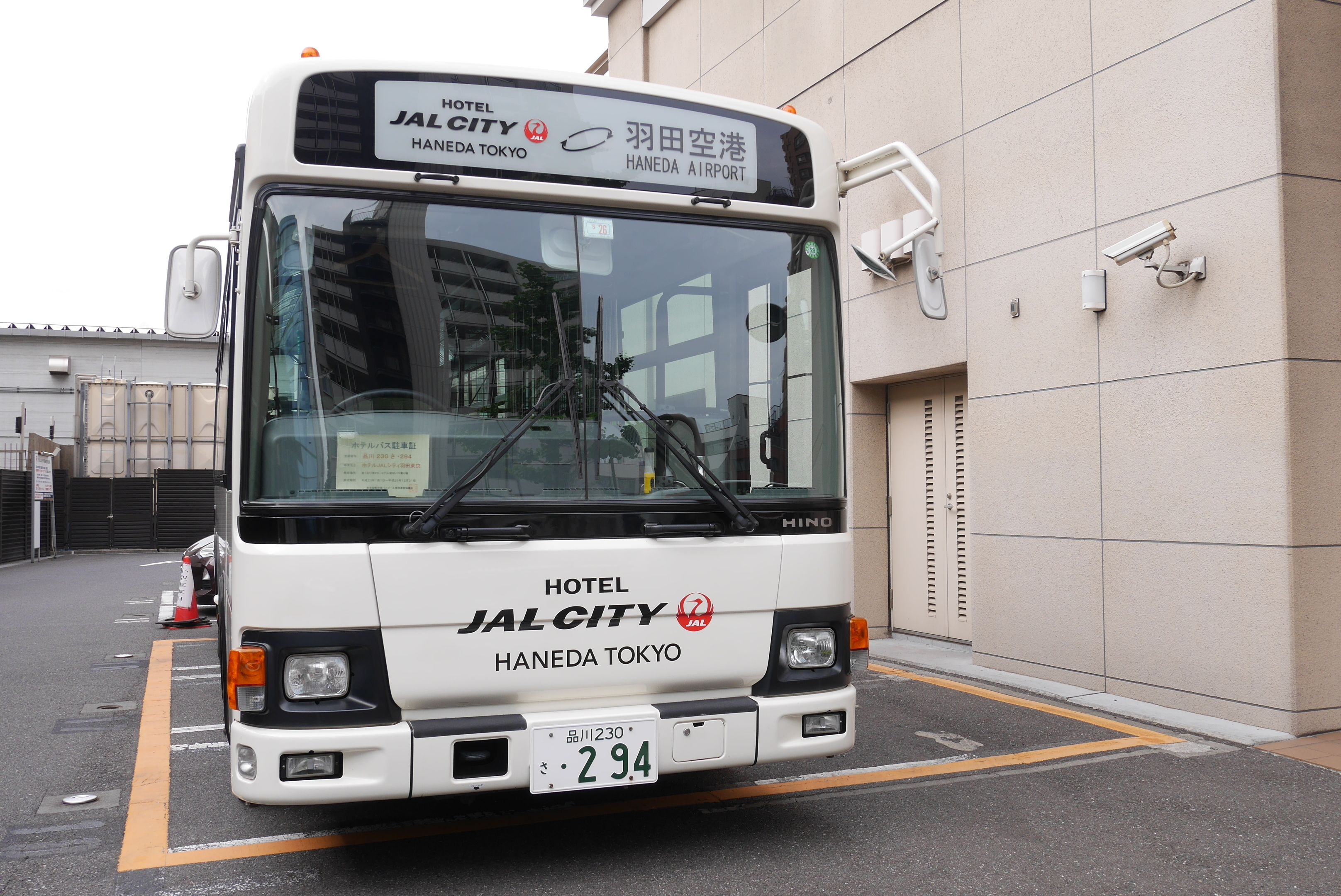 A white bus with "HOTEL JALCITY HANEDA TOKYO" and "HANEDA AIRPORT" written on the front.