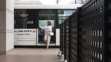 A hotel entrance with a sign for "Hotel JALCITY HANEDA TOKYO" and a person exiting the building.