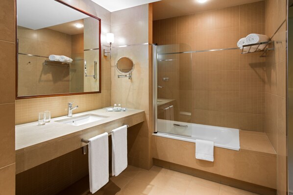 Un baño moderno con dos lavabos, un espejo grande, ducha envuelta en vidrio y una bañera.