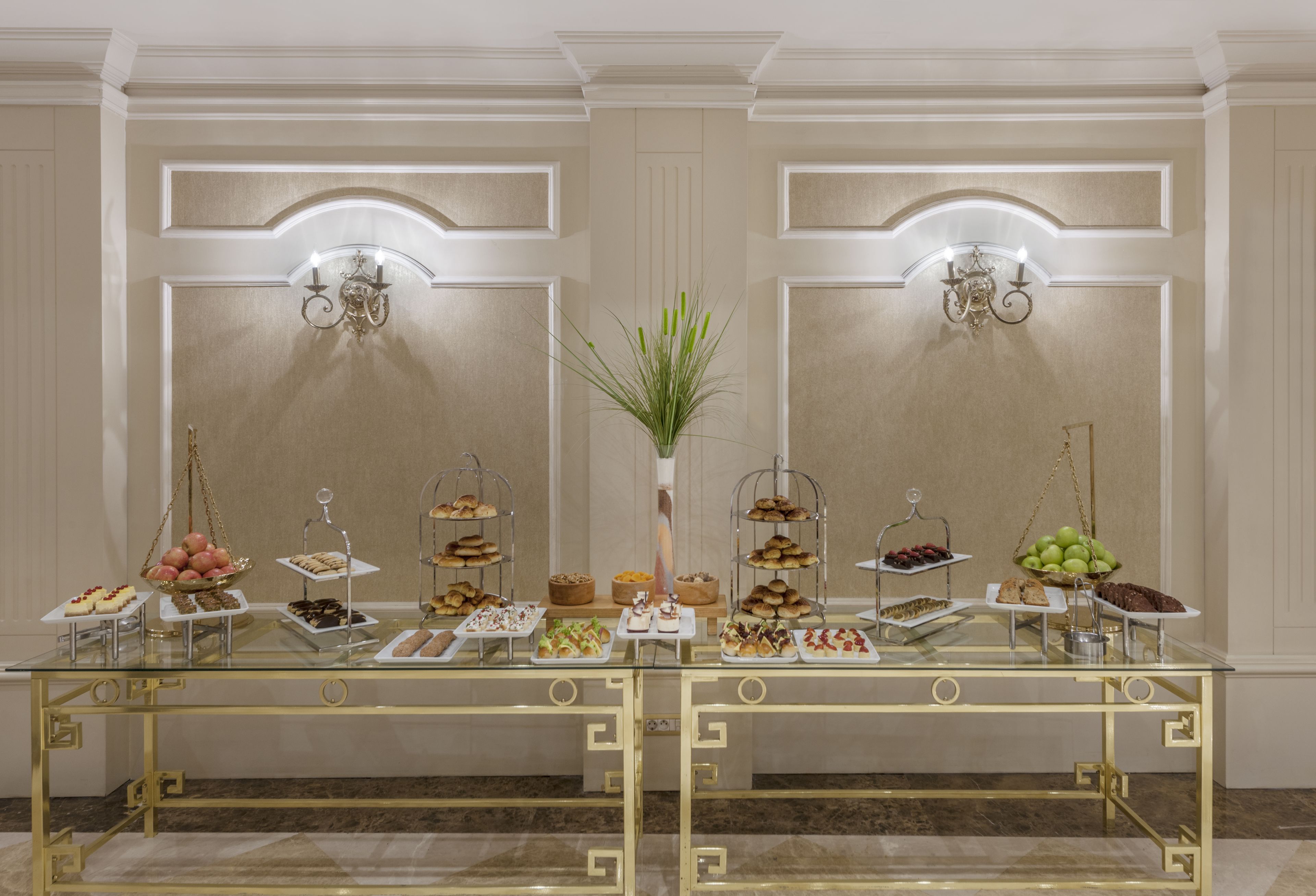 A buffet table with various food items and a decorative plant in the center.