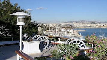 A coastal cityscape with a marina, a white lamp post, and decorative wheels.