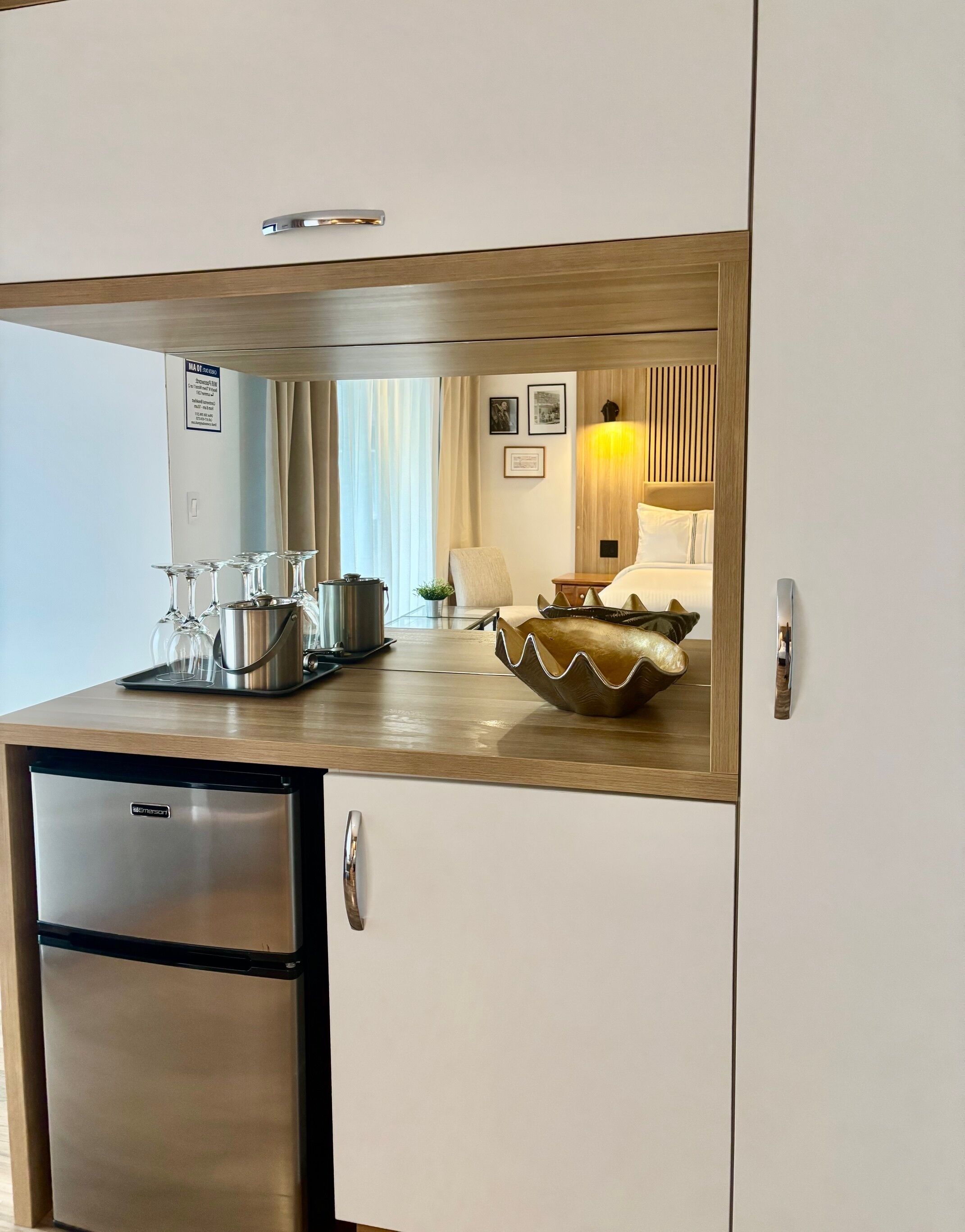 A compact kitchen with a refrigerator, a coffee maker, and a bowl on the counter.