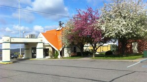 A parking lot with a building featuring a red roof and a sign that reads "CLEARANCE 10' 6"". - Americas Best Value Inn Phillipsburg (Phillipsburg)