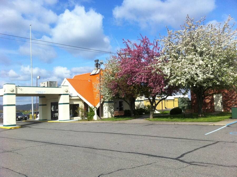 Un estacionamiento con un edificio de techo rojo y un letrero que dice "CLEARANCE 10' 6".