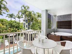 Ein Balkon mit Pool, weißen Stühlen, einem Tisch und einem Whirlpool.