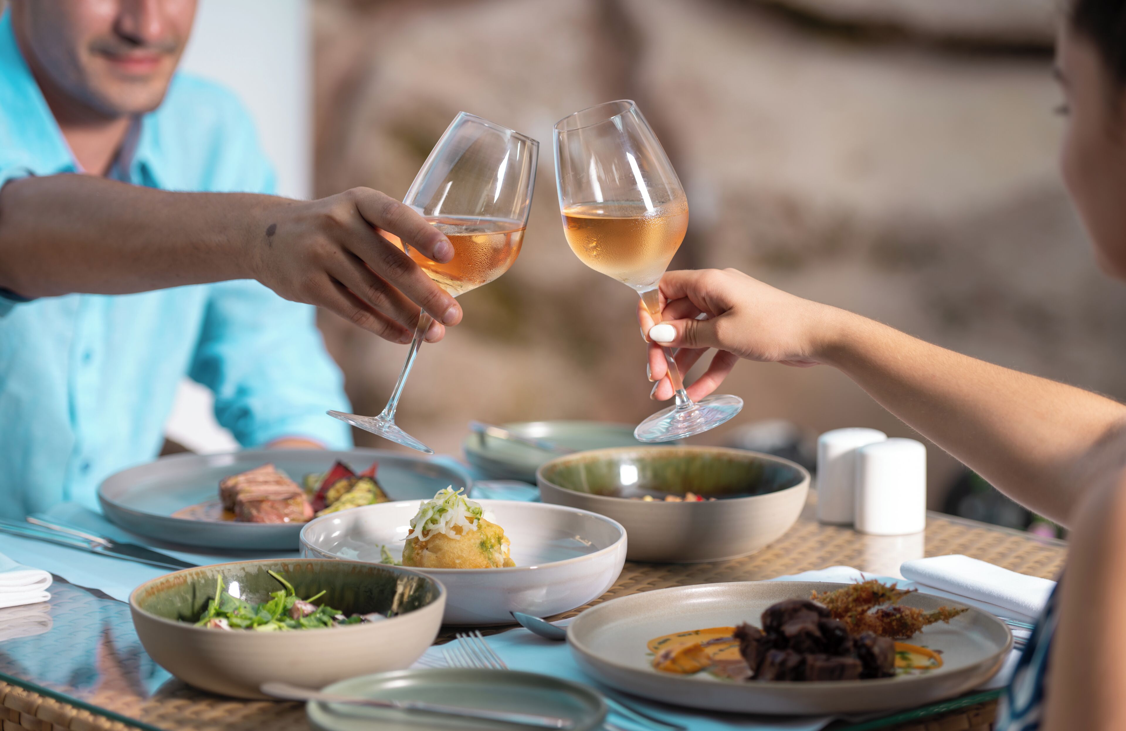 A dining table with multiple dishes and glasses.
