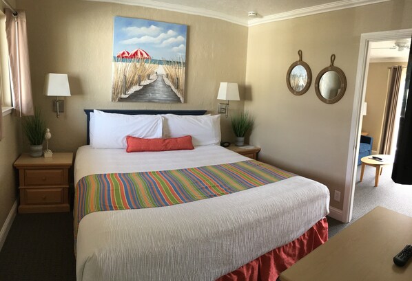Relax in a serene space with a large bed, two bedside tables, and a charming painting above.