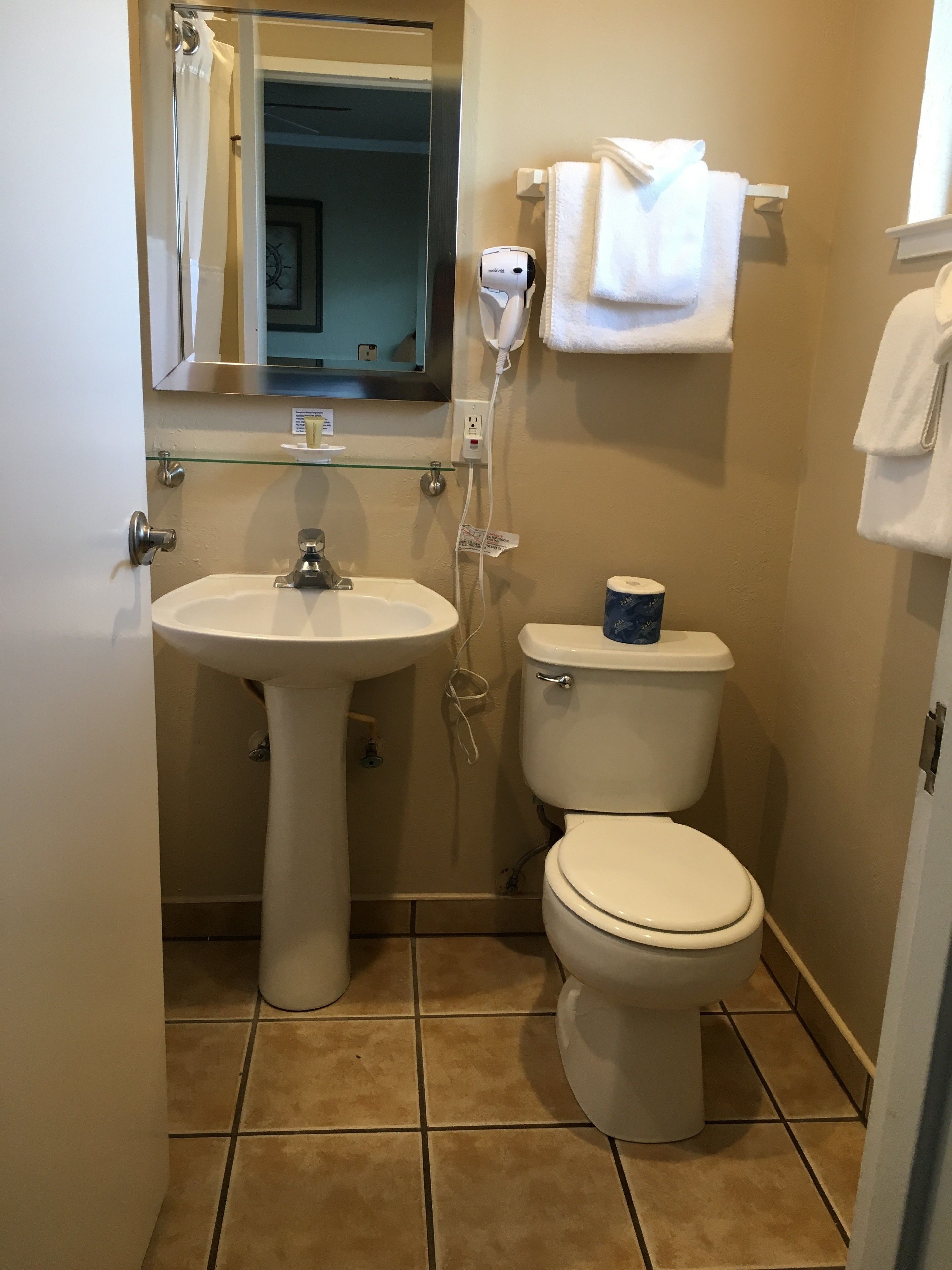 Ein kleines Badezimmer mit einem Standwaschbecken, einer Toilette und einer Duschkabine aus Glas.