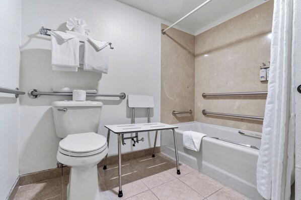 A modern bathroom with a toilet, bidet, and bathtub, equipped with grab bars and a towel rack.