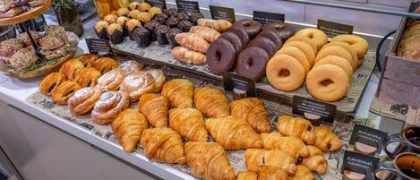 A bakery display with various pastries and doughnuts.