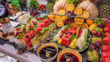 Une variété de fruits et de desserts étaient exposés, notamment des pastèques, des raisins et différentes sortes de salades de fruits.