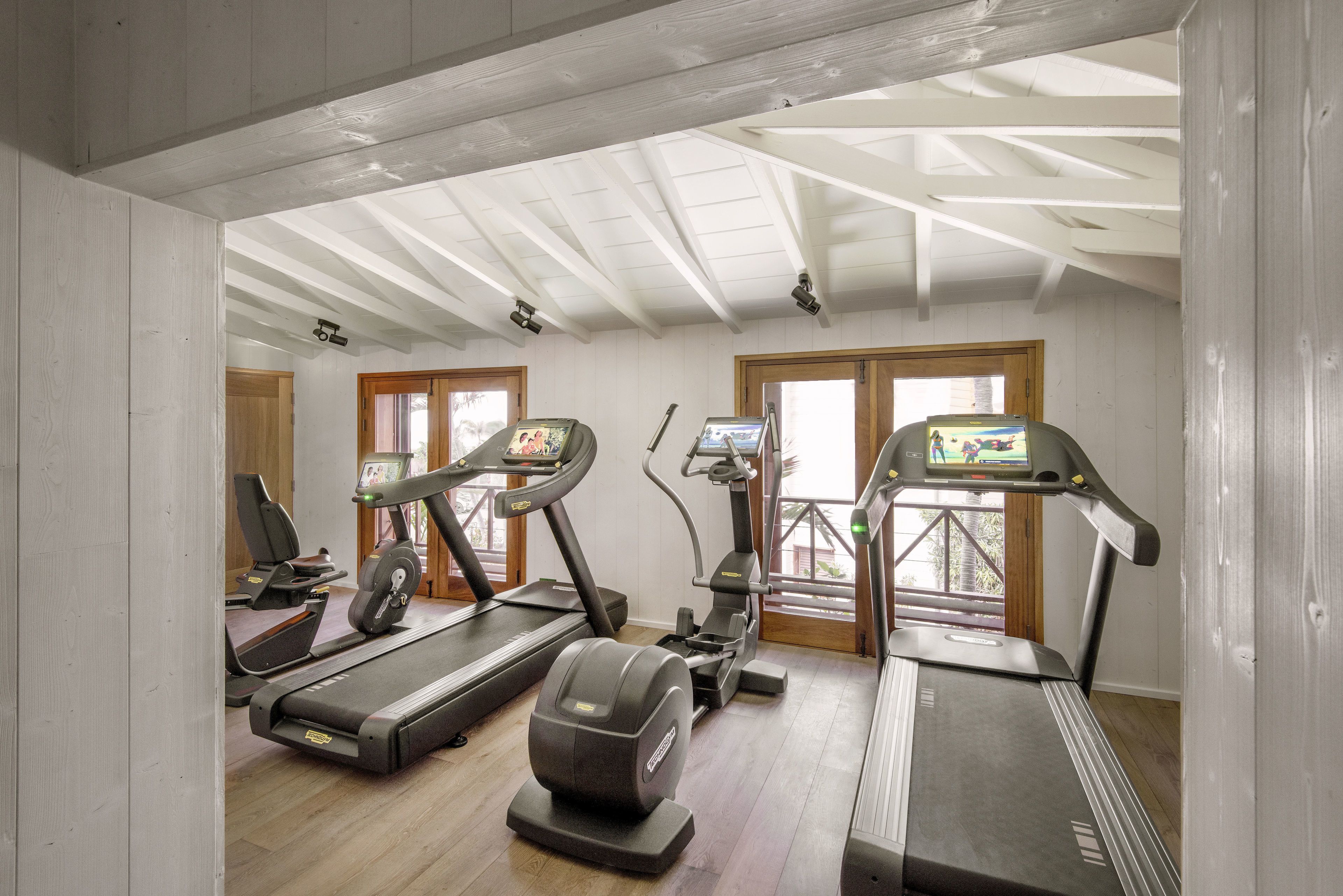 A gym with treadmills, elliptical machines, and a stationary bike.